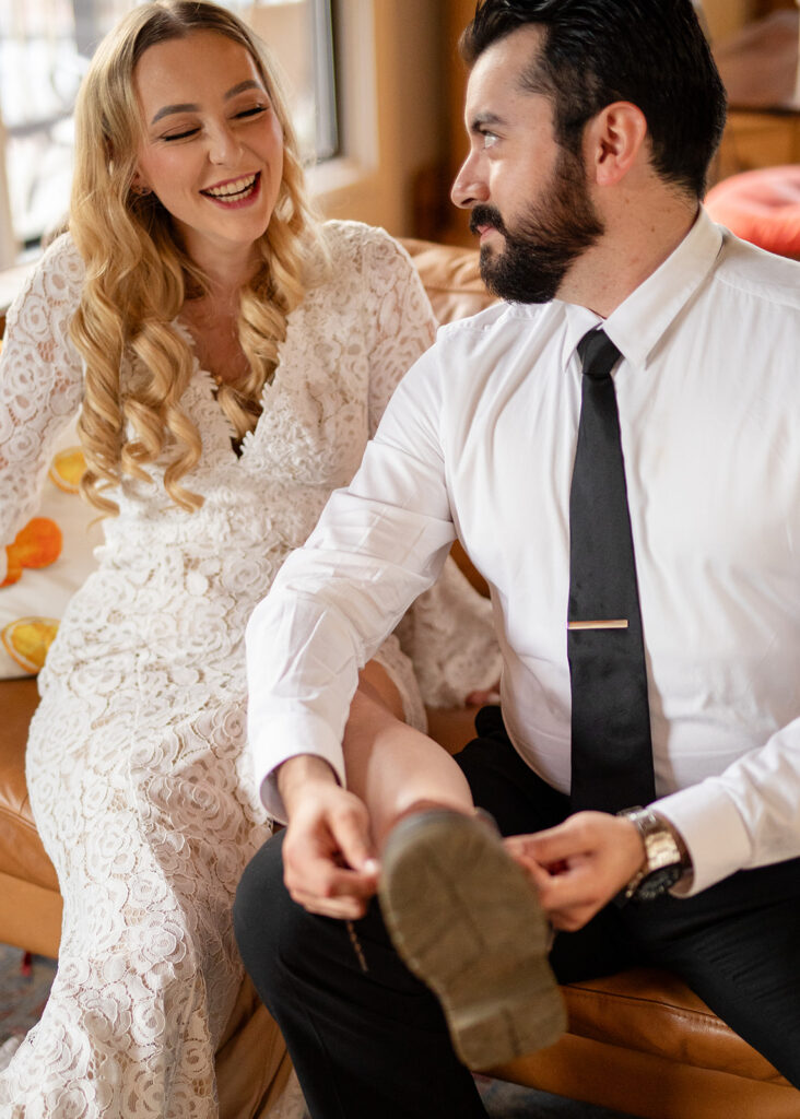 groom helping his bride tie her hiking boots