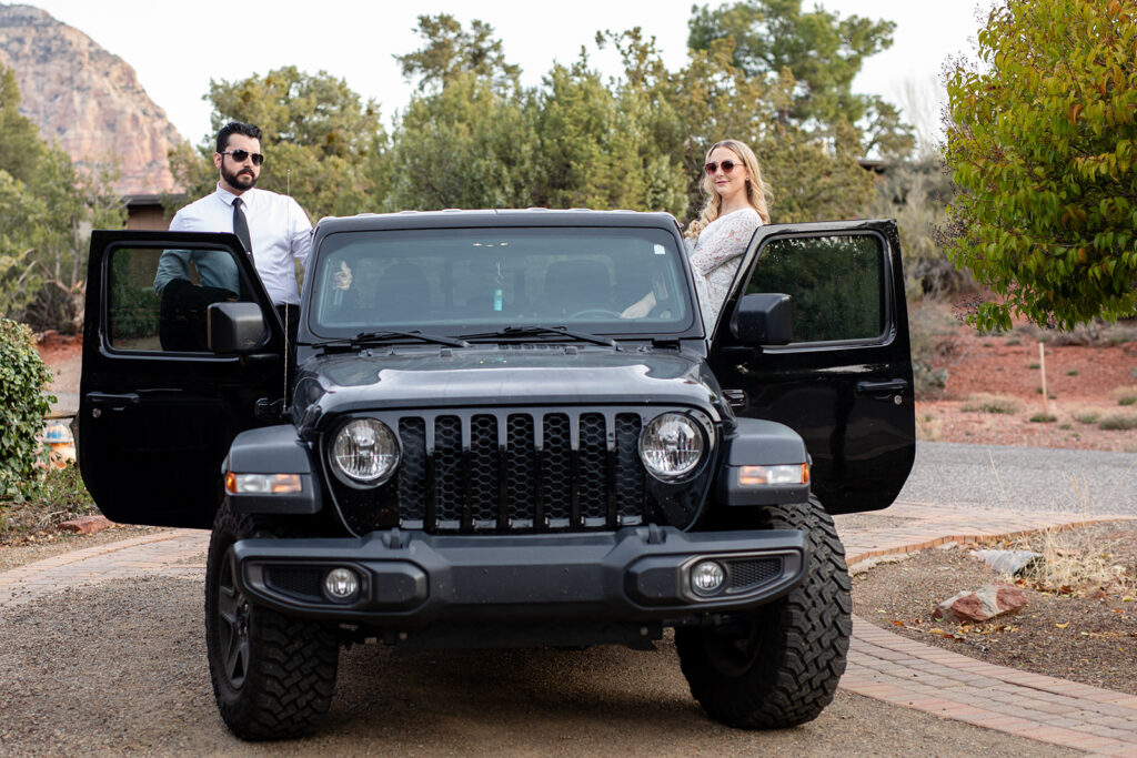 bride and groom posing at their jeep ready to go for adventures in sedona