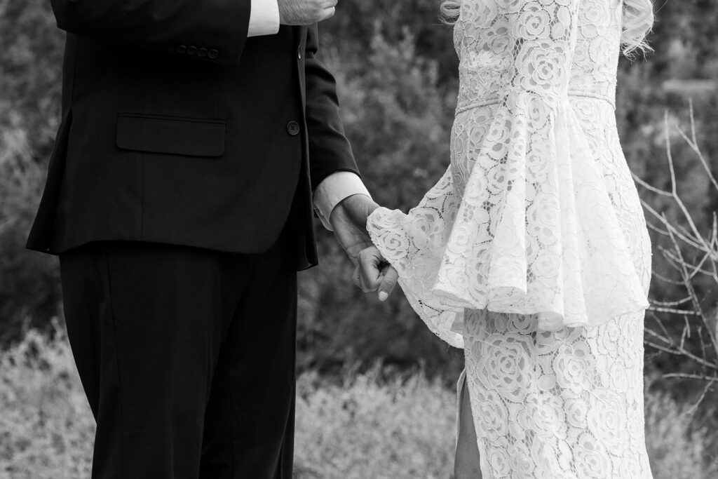 black and white elopement photography of bride and groom holding hands