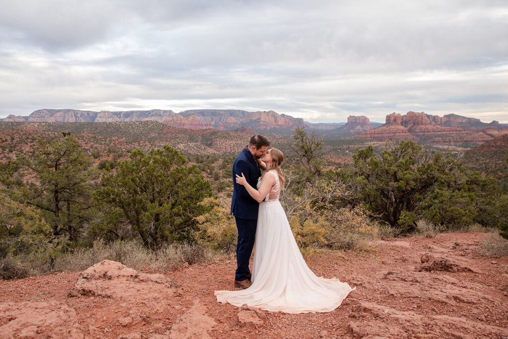 romantic elopement couple kiss with dramatic sedona landscapes in the backdrop