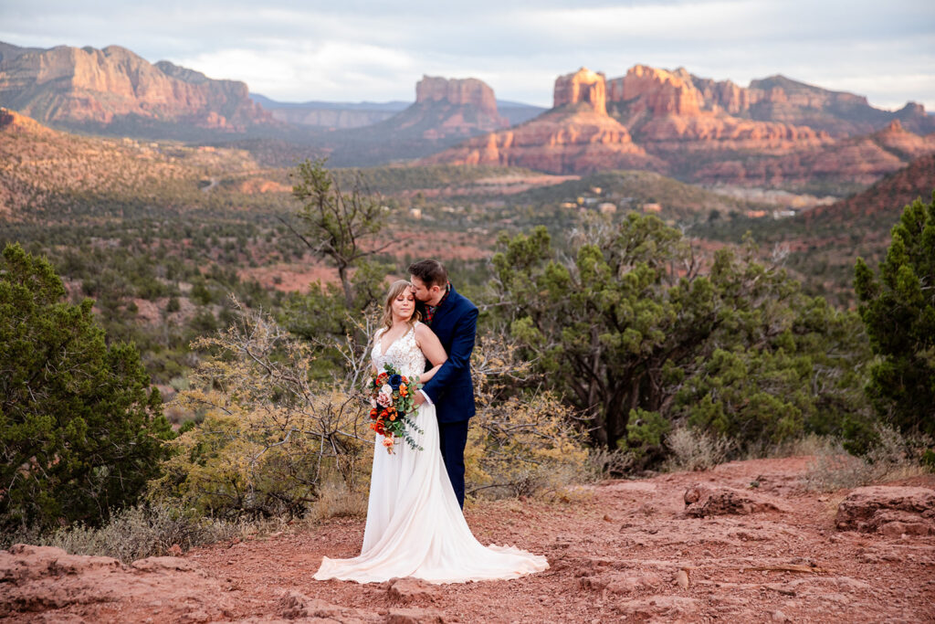 romantic elopement couple hug with dramatic sedona landscapes in the backdrop