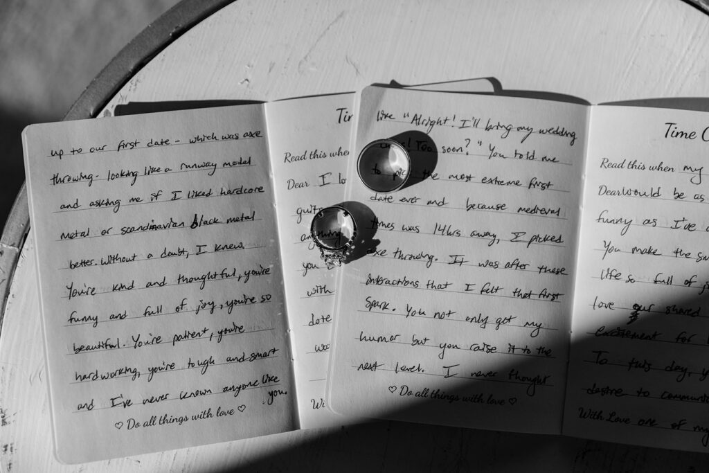 black and white detail shot of handwritten vows and wedding rings