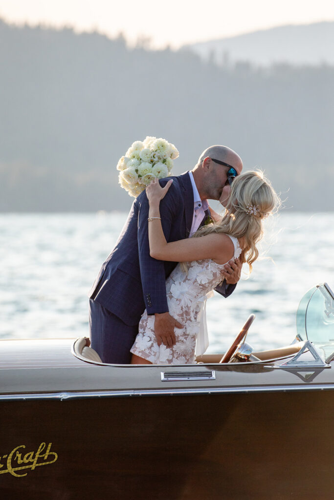 bride and groom kissing on a classic boat during their Lake Tahoe boat elopement