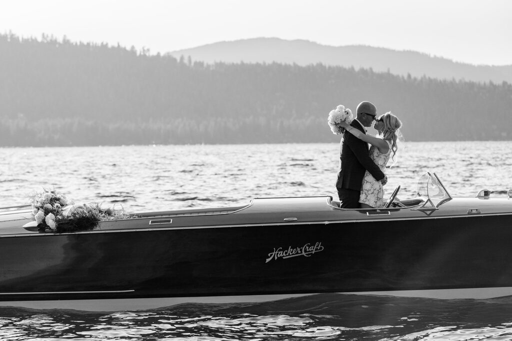 black and white elopement couple photo on a classic boat surrounded by lake tahoe landscapes