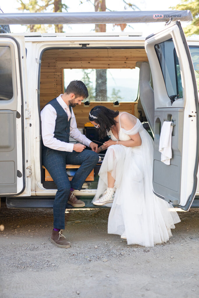 bride and groom cutting and eating their elopement cake in their camper van