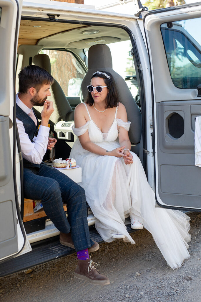 bride and groom cutting and eating their elopement cake in their camper van