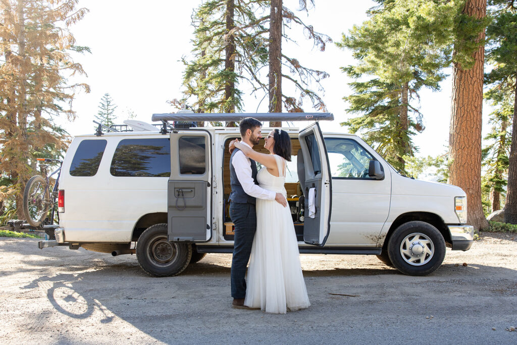 bride and groom cutting and eating their elopement cake in their camper van