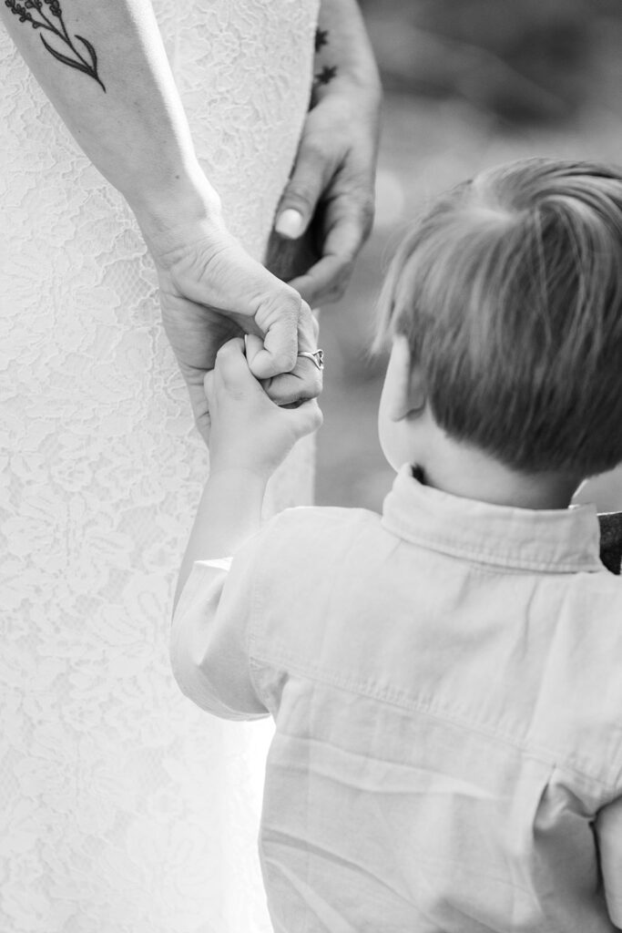 couple's son holding mom's hand during the elopement ceremony