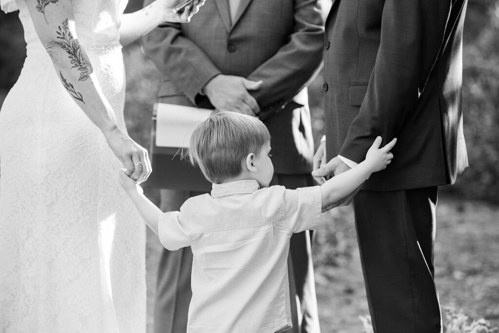 couple's son holding mom's hand during the elopement ceremony