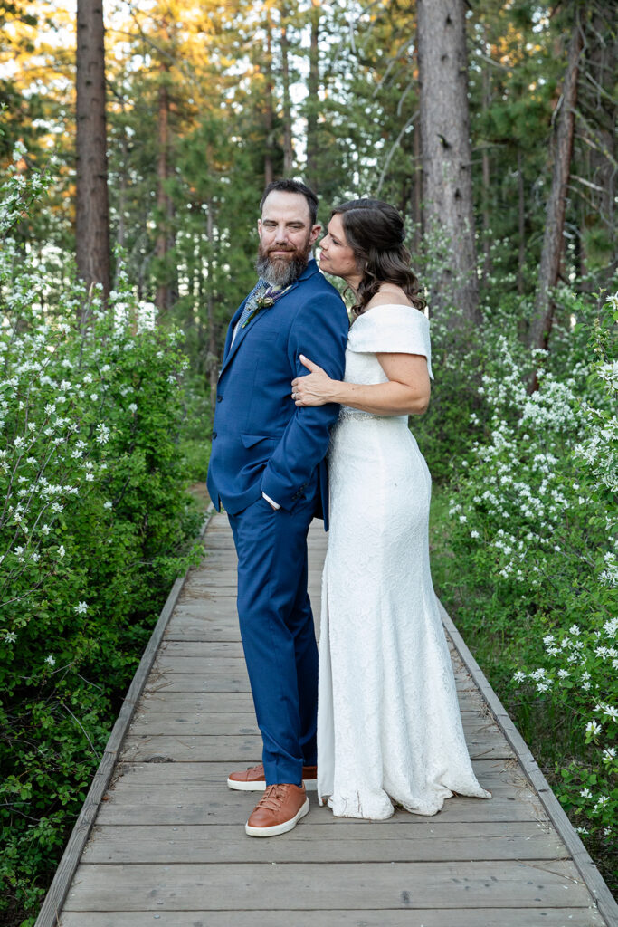 bride and groom in a lush green forest surrounded by wildflowers in Lake Tahoe