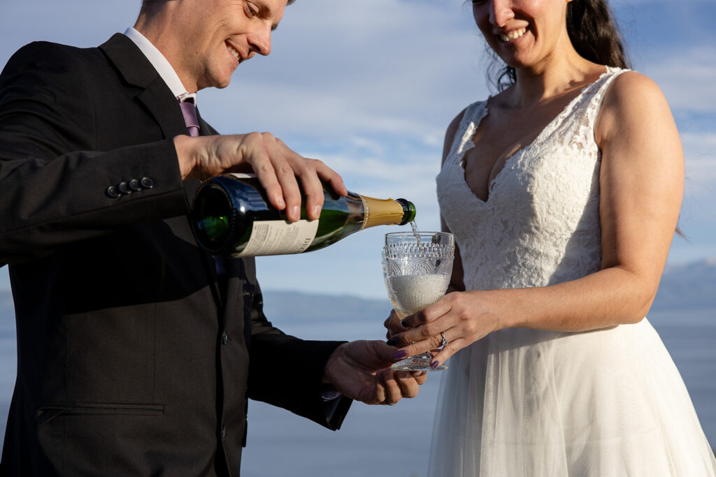 bride and groom enjoying a glass of champagne together during their simple elopement day at lake tahoe