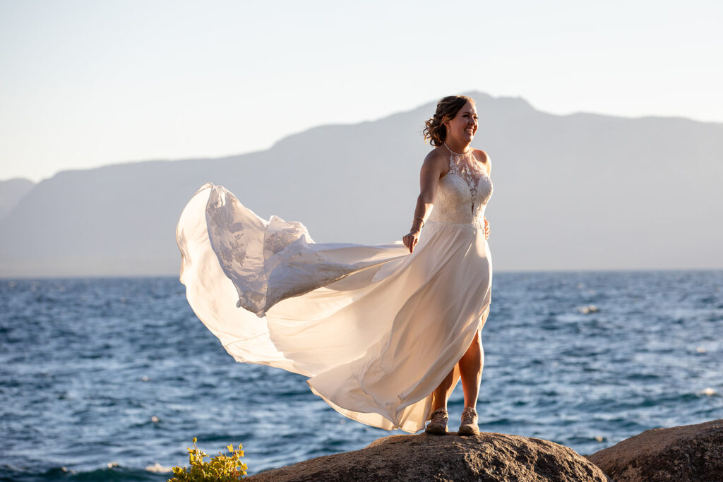 bride standing on a large rock surrounded by water views